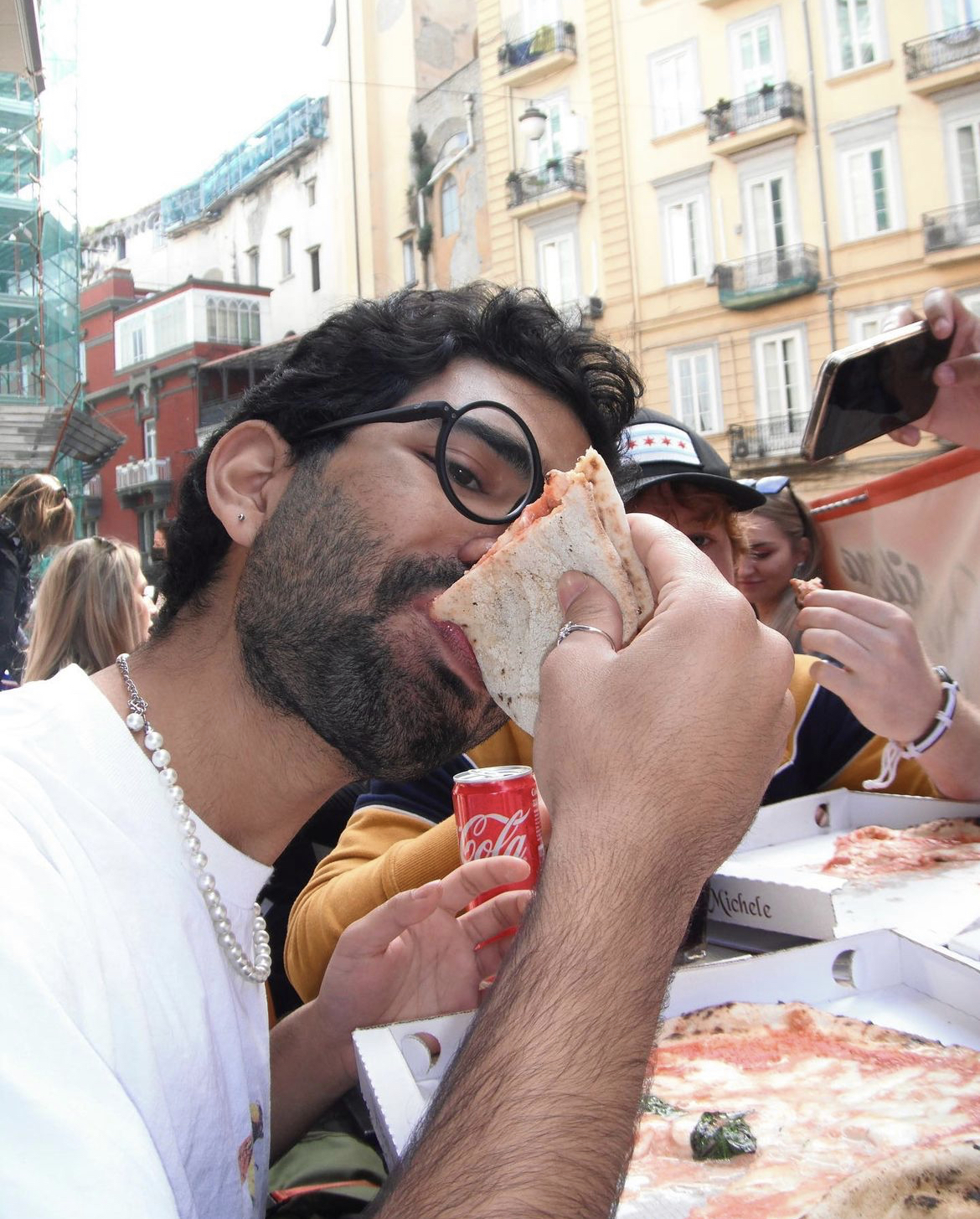 Ahmed eating a slice of pizza in Naples, Italy