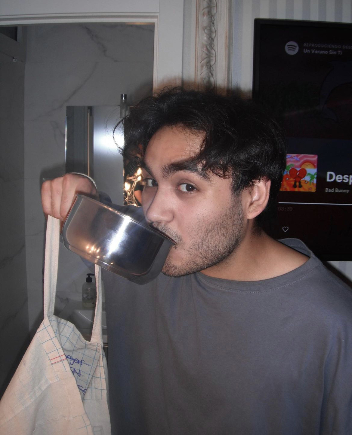 Chava sipping out of a cooking pot at a party