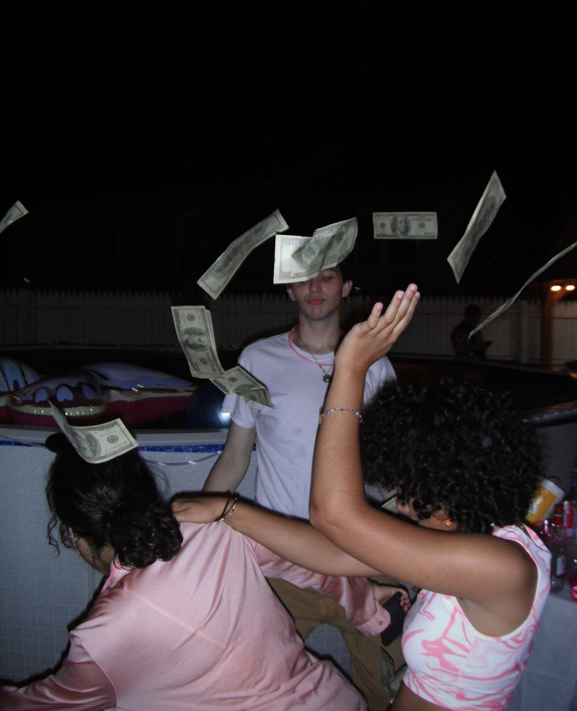 Anahy and Kelly dancing with fake bills flying through the air