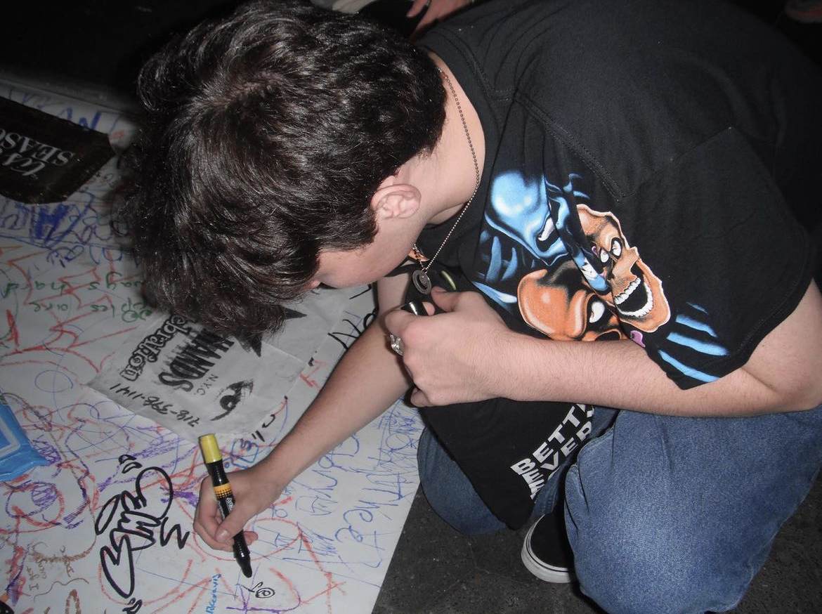 Jamie tagging a poster in the park