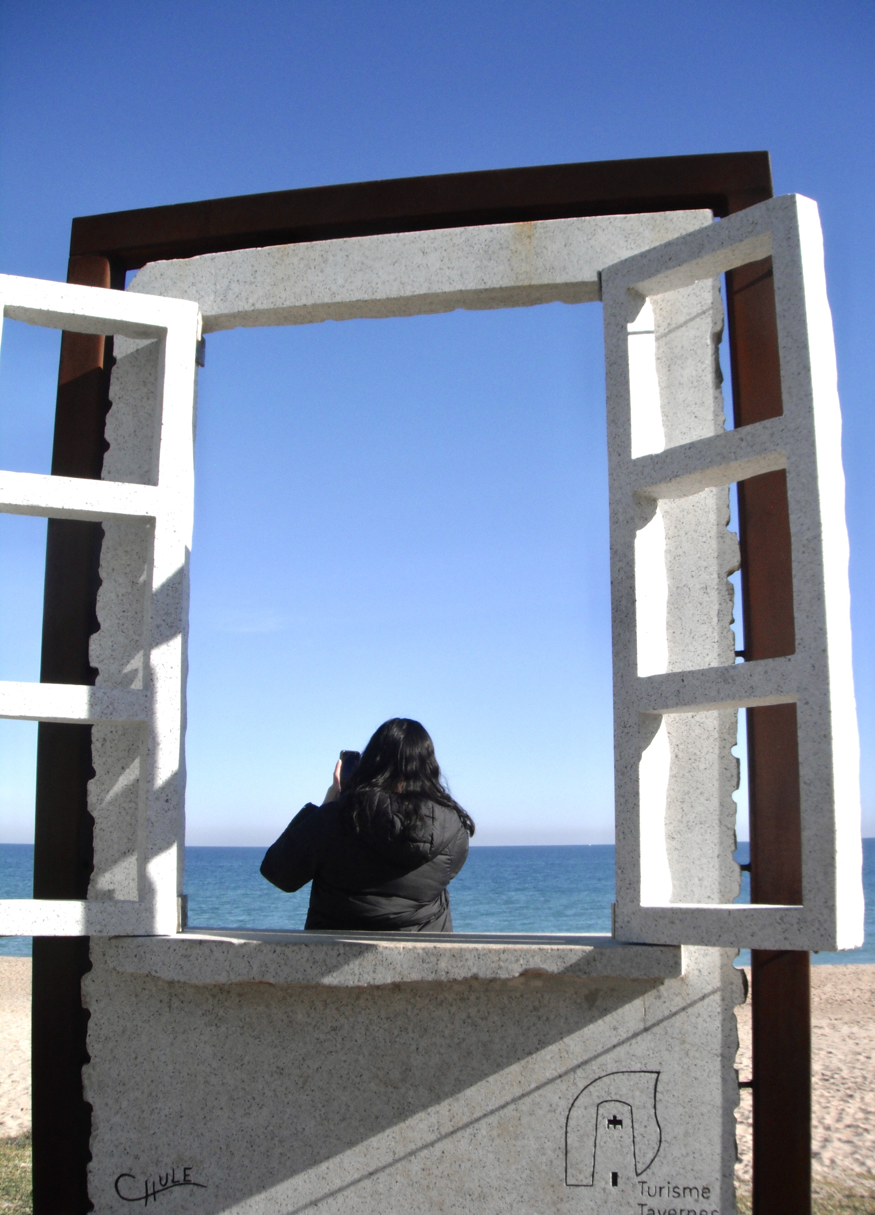 Woman standing in front of a window on a beach